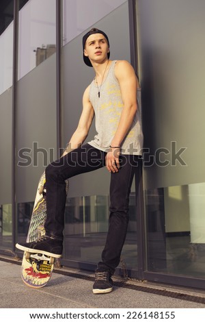 Young blonde guy on skateboard in casual outfit in the urban city outdoors. active. sport