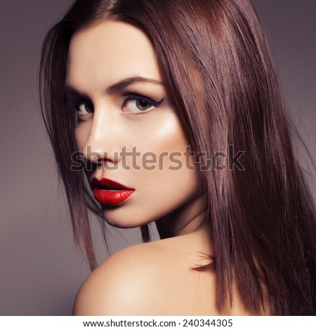 Beauty close up portrait of a brunette woman with red lipstick. Pure skin. Toned image
