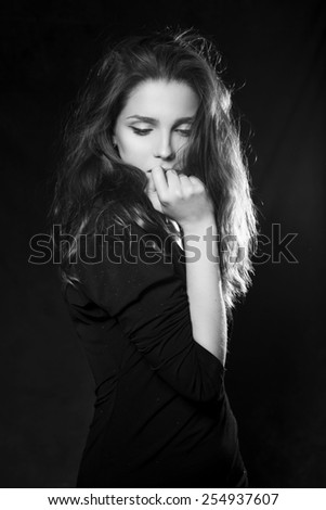 Beautiful woman in black sweater on black background. Black and White. Monochrome portrait. Dramatic. Sensual