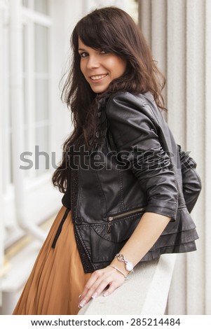 Brunette beautiful stylish caucasian woman in casual outfit on a walk on european city street