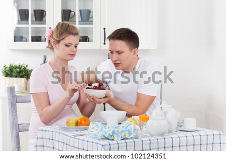 Happy pregnant family with fresh  fruit  on the  house kitchen.