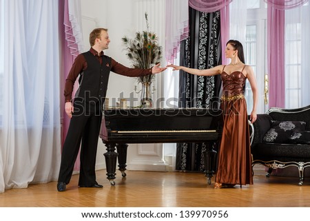 Dancing young couple in the room.