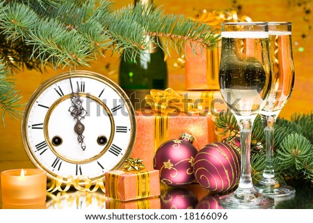 Decoration with an antique clock, firtree branch, gift boxes and champagne glasses