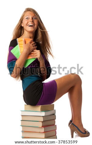 The attractive student sits on a pile of books with coloured writing-books on a white background.