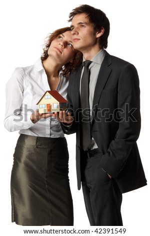 The young happy family holds house model in hands on a white background. House purchase concept.