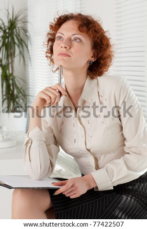 Businesswoman with clipboard sits in the office.