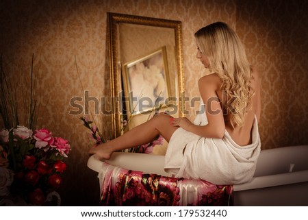Young woman wiping body by a towel in house  bathroom. Concept  of body care.