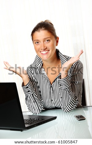 A young business woman with open hands with laptop and cell