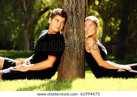 Young couple resting in the park near the tree