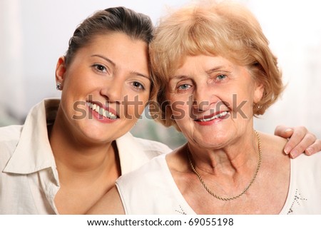 A beautiful portrait of grandma and granddaughter smiling over white background