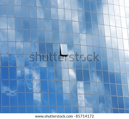 A picture of a group of modern building windows only one is open