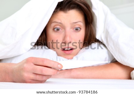 A portrait of a young woman lying in bed with high fever focus on hand