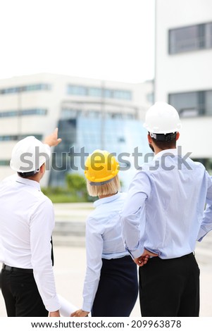A picture of a group of architects on site pointing at modern buildings
