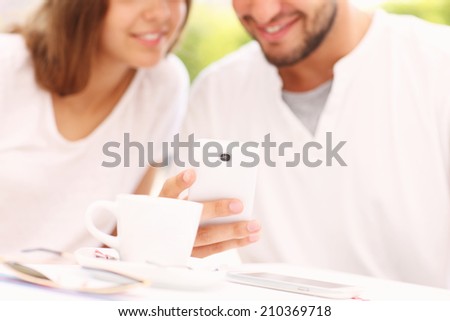 A picture of a blurry young couple and smartphone