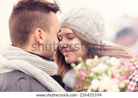 A picture of a romantic couple with flowers on an autumn walk