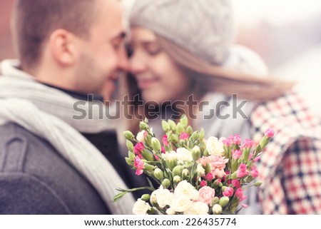 A picture of flowers and kissing couple in the background