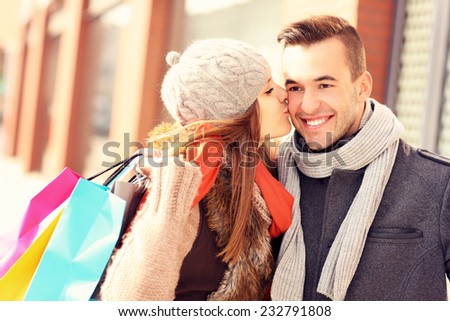 A picture of a beautiful woman kissing a man while shopping