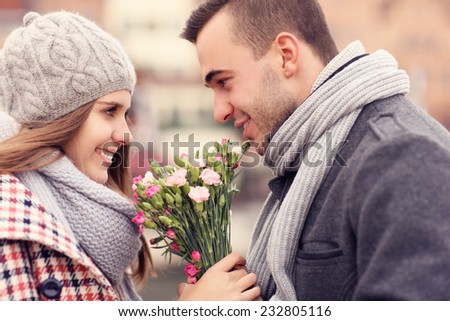 A picture of a romantic couple on a date holding flowers