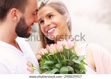 A picture of a young romantic couple with flowers in the city