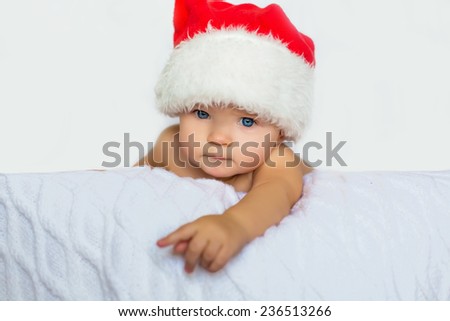 cute beautiful  baby on white blanket in red christmas hat