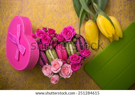 pink present box heart shape with flowers tulips macaroons and tablet yellow background for valentines mother woman day easter with love
