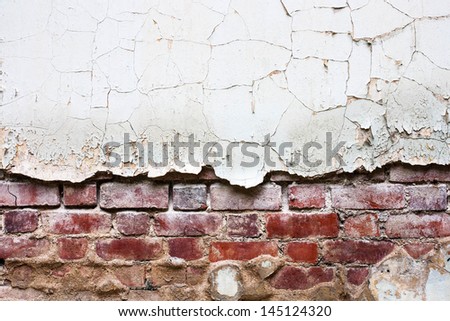 crack of the old wall show red brick under them skin.