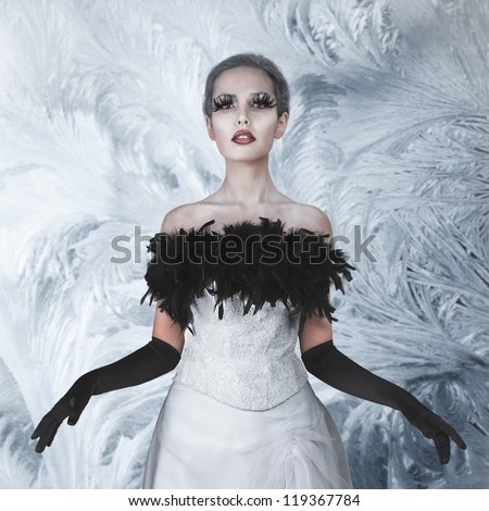 Elegant woman in long white dress at mystic winter garden
