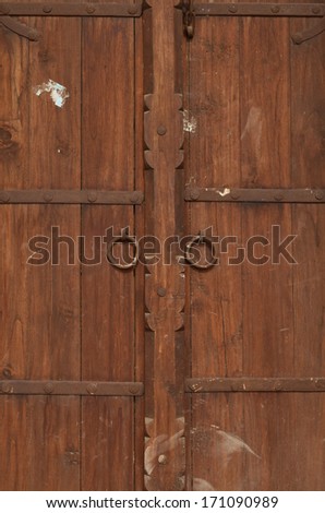 Light brown colored wooden door frame background with metal hooks, architecture followed in India in bygone era for doors