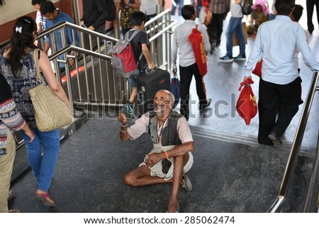 Editorial: Gurgaon, Delhi, India: 06th June 2015: An unidentified old poor man begging from people at Gurgaon M.G Road Metro Station