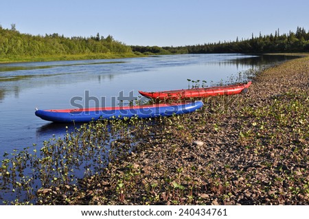 Taiga river Paga, Russia, the Polar Urals.  Inflatable kayaks on the shore of the river.