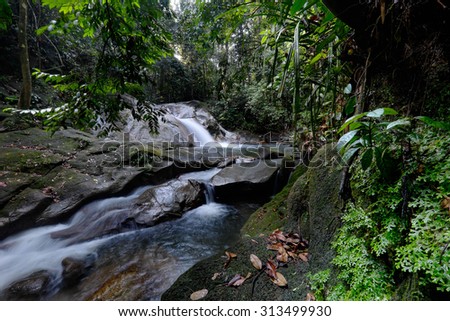 Scenery of a series of waterfall stream through green mossy rain forest in Selangor, Malaysia.