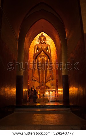 BAGAN, MYANMAR - MAY 4: Standing Buddha Kassapa at south facing part of the Ananda temple adorned by believers by sticking goledn leaves on statue on May 4, 2013 in Bagan, Myanmar.