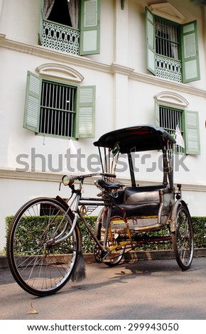 March 20, 2015: Old vintage retro human power cute rickshaw, vechicle of the past as tourist attraction today, at historical colonial style house: KHUM CHAO LUANG, in MUENG PHRAE district in THAILAND.