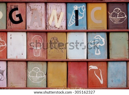 raws of used tin thin metal large rectangular cookies box painted and installed in a wall with some alphabets on the box