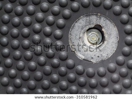 black plastic round plate, part of an old exercise machine, crop and close up on anti slip round buttons .