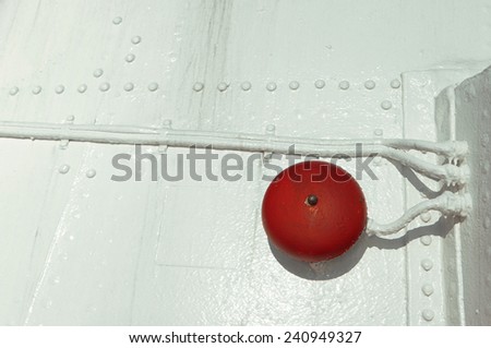 red alarm bell on white boat hull