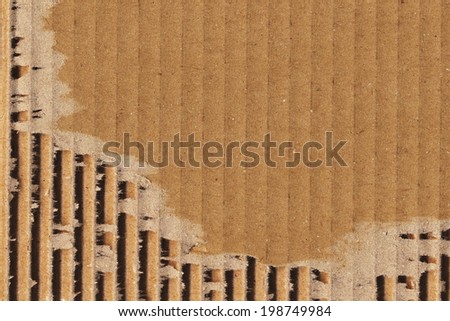 Photograph of recycle brown corrugated striped cardboard, coarse grain, obsolete, torn, grunge texture sample