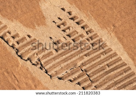 Photograph of recycle Brown corrugated striped cardboard, coarse grain, obsolete, torn, grunge texture sample.