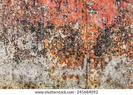 Old, obsolete, badly corroded river raft hut floater metal surface, covered with cracked decomposed layers of red paint, tar and rust.