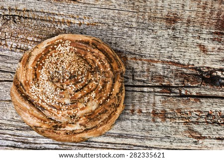 Croissant Sesame Puff Pastry Roll, on old weathered, cracked Wood surface.