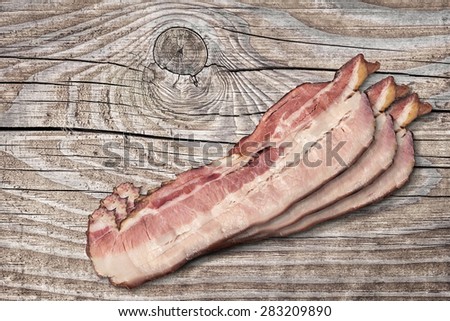 Pork Belly Bacon Rashers on Old Knotted Wooden Table Surface