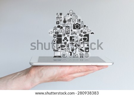 Smart home automation and mobile computing concept with male hand holding tablet