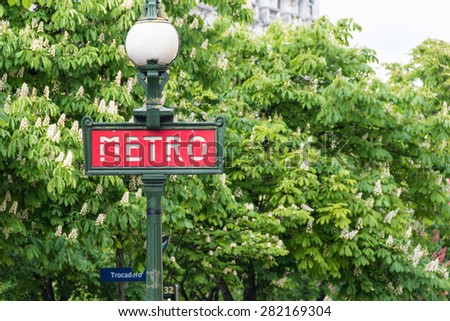 PARIS MAY 07, 2015: French Metro sign of the Paris subway during spring time with green trees in the background taken on May 07, 2015 in Paris, France