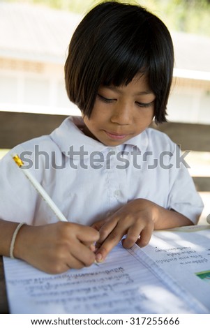 MAE SOT THAILAND - NOV26 : Ethnic Karen student  is copying Thai handwriting practice at the school Ban Khun Huai Mae Sot, Tambol Phra That Pha Daeng, Mae Sot, Tak, Thailand on NOVEMBER26, 2014