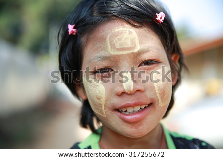 MAE SOT THAILAND - JAN3 : Unidentified girl descendant migrant worker use of Thanaka, a traditional Myanmar cosmetic painting on face at Mae Sot, Tak, Thailand on JANUARY3, 2014