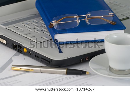 White laptop, glasses, pen, cup