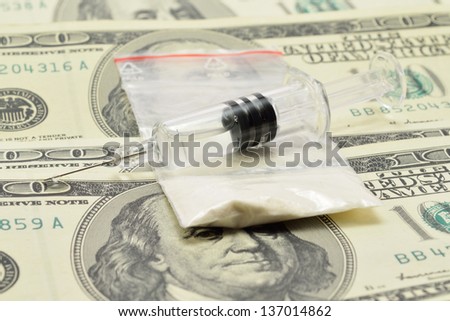 syringe with a drug is on the money with white powder