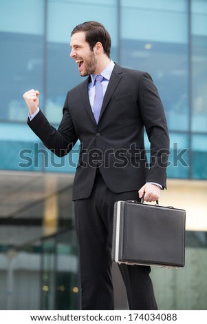 successful businessman happy after a good job in front of an office building