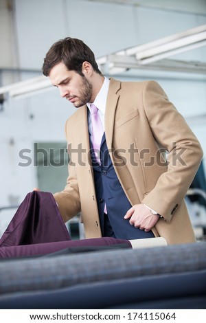 Profile of a business man in a factory checking quality of a textile material