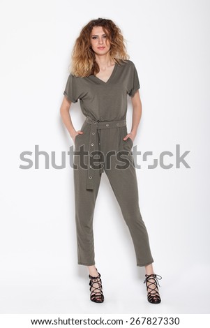 young sexy woman posing in gray rompers on white background